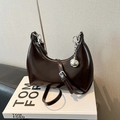 Detailed close-up of chocolate brown hobo bag with glossy finish and silver sphere charm - Brown