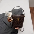 Borsa a secchiello a pieghe marrone scuro con chiusura oro e ciondolo su blazer - Caffè con Ciondolo