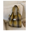 Close-up of yellow and grey plaid wool tote bag with brand label on a soft sofa - With Pendant / Yellow Check