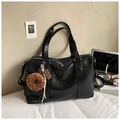 Detalle de un bolso tote negro de gran capacidad con cremallera y dijes decorativos - Con Colgante / Negro