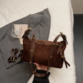 Nahaufnahme der dunkelbraunen Wildledertasche mit Metallösen und Premium-Textur - Kaffeebraun
