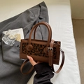 Detail van vintage crossbodytas met luipaardprint, dubbele handvatten en goudkleurig beslag - Bruin