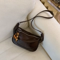 Detalle de bolso dumpling de cuero marrón retro con cuentas de madera y cremallera plateada - Café con Colgante