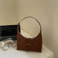 Sac sous le bras croissant en daim vintage marron avec boucle sur un bureau blanc - Marron