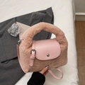 Detail einer rosa Plüschhandtasche mit flauschigem Griff und silberner Schnalle - Rosa