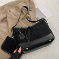 Schwarze Tragetasche aus Wildleder und Leder mit Goldnieten in minimalistischem Büro - Schwarz