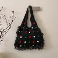 Detail of black knit tote bag featuring colorful fuzzy pom-poms and long side tassels - Black
