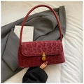Detail shot of red leopard print baguette bag with golden clasp on grey suit jacket - Burgundy