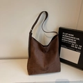Macro detail of the dark brown suede tote bag featuring fine stitching and silver buckle - Coffee