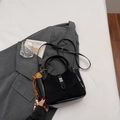 Minimalist black bucket bag in mixed leather with metallic buckle and floral charm - Black with Pendant