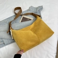 Details der gelben Wildleder-Hobo-Tasche mit braunem Lederriemen und Perlenanhänger - Gelb