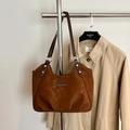 Dettaglio della borsa tote in pelle scamosciata marrone con etichetta e rivetti dorati - Marrone