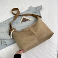 Detail der khakifarbenen Wildledertasche mit Lederriemen und dekorativem Perlenanhänger - Khaki