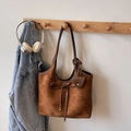 Detail van vintage bruine shopper met suède textuur en verfijnde strikdecoratie - Bruin