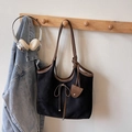 Detail van zwarte suède shopper met lederen strik en een bruine decoratieve hangtag - Zwart