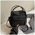 Detalle del bolso de nailon negro que muestra los bolsillos laterales y la bandolera - Negro