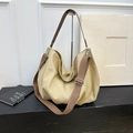 Nahaufnahme der Retro-Beige-Canvas-Hobo-Tasche mit braunem Ledergriff und silbernen Beschlägen - Khaki