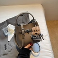 Détail d'un sac seau en cuir grainé marron foncé avec fermoir argenté et charm ours - Gris Éléphant avec Pendentif