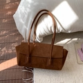 Sac fourre-tout en daim marron avec fermeture à rabat posé sur un coussin blanc - Marron