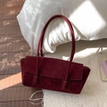 Vue détaillée du sac fourre-tout en daim bordeaux avec design à rabat minimaliste - Rouge