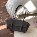 Vue détaillée d'un sac cabas en daim gris foncé posé sur un tapis blanc moelleux - Gris