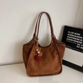 Detailansicht der braunen Wildledertasche mit bunten Quasten und Lederbesatz am Rand - Braun