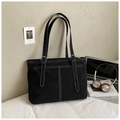 Detail of black canvas tote bag showing white contrast stitching and silver metal buckles - Black