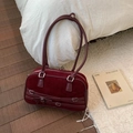Close-up of burgundy suede bowling bag with bow details on a white bed background - Red
