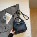 Classic black pebbled leather bucket bag with metal buckle on white bedding - Black without Pendant