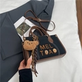 Detail der Canvas-Handtasche mit Lederbesatz, Holzknöpfen und süßem Bären-Anhänger - Schwarz