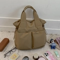 Detail shot of khaki nylon tote bag with front pockets and lifestyle accessories - Khaki