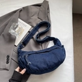 Dettaglio di una borsa a mezzaluna in denim blu navy con ampia tracolla regolabile - Blu scuro