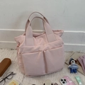 Detailansicht der rosa Nylontasche mit großen Vordertaschen und Kordelzug-Design - Hellrosa