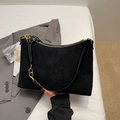 Close-up of black matte tote bag featuring vintage gold chain strap and woven leather detail - Black