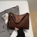 Detail of vintage brown suede tote bag featuring contrast leather trim and side chain charm - Coffee