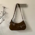 Dettaglio della borsa sottobraccio in pelle scamosciata marrone con occhielli e fibbie - Marrone