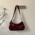 Detail showing the burgundy suede texture and crisscross buckle straps on a crescent bag - Red