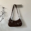 Dettaglio della borsa sottobraccio in pelle scamosciata caffè con occhielli e fibbie metalliche - Marrone