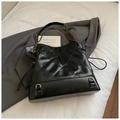 Close-up of black quilted leather shoulder bag with vintage gold chain and hardware detail - Black