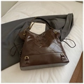 Detail of deep brown quilted tote bag with golden chain strap and polished leather texture - Brown