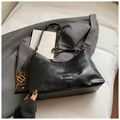 Detailansicht der schwarzen Handtasche aus Kunstleder mit Goldteilen und Leoparden-Anhänger - Schwarz mit Anhänger