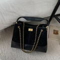 Detail of black quilted bucket bag featuring gold chain straps and twist lock closure - Black Large