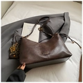 Details einer dunkelbraunen Tasche mit Litschi-Struktur, Logo und Leoparden-Anhänger - Kaffee mit Anhänger