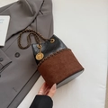 Detail van een gewatteerde emmer-tas van leer en suède met vintage muntketting - Bruin