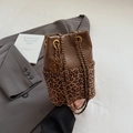 Detail van luipaard bucket bag met gewatteerd bruin leer en gouden kettingriem - Luipaardprint