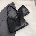 Draufsicht der schwarzen Leder-Tote-Bag mit passender kleiner Reißverschlusstasche auf Sakko - Schwarz