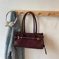 Dettaglio della borsa baguette marrone rossiccio rétro con inserti in pelle scamosciata - Marrone
