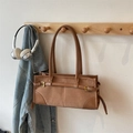 Dettaglio della borsa baguette in pelle scamosciata marrone con cuciture e fibbie dorate - Cachi