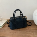 Detail view of navy blue frosted leather Boston bag with metal hardware on wood surface - Black without Pendant
