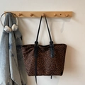 Schicke Shopper-Tasche mit Leopardenmuster und schwarzen Schultergurten an der Wand - Braun